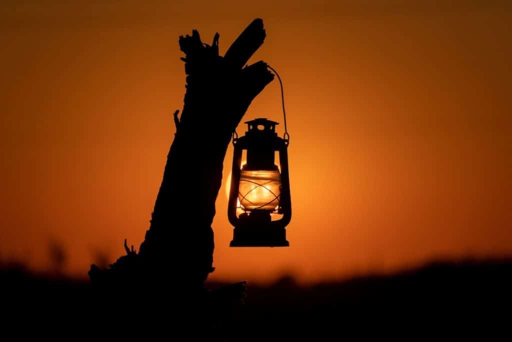 Lantern Hanging On Driftwood At Sunset On The Beach