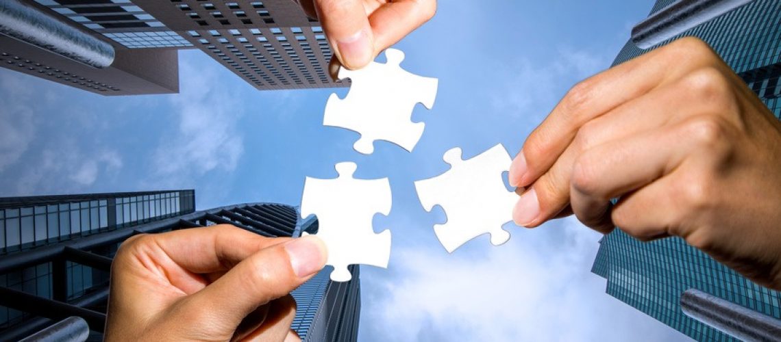 three hands holding piece of jigsaw puzzle on cityscape background. business partnership concept. business matching.